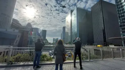 Un Super Puma héliporte une grue sur la tour Opus à La Défense