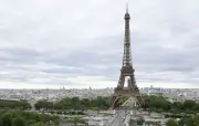 Un homme escalade la tour Eiffel et accroche un drapeau américain